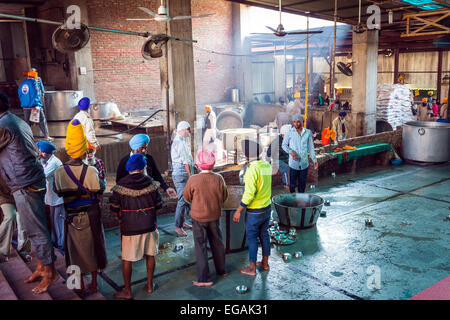 Volunteers working in the kitchens of the communal dining room of The Golden Temple, Amritsar, Punjab, India Stock Photo