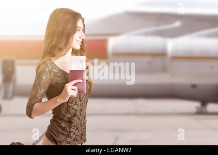 Woman about to board an airplane in an airport runaway at sunset Stock Photo