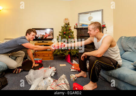 Brothers Exchanging Gifts On Christmas Day, Sussex, England Stock Photo