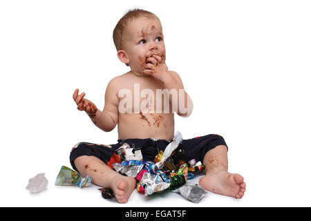 kid eats a lot of chocolate candies Stock Photo