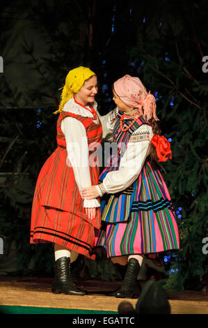 Two women wearing costumes perform a traditional Polish dance Stock Photo