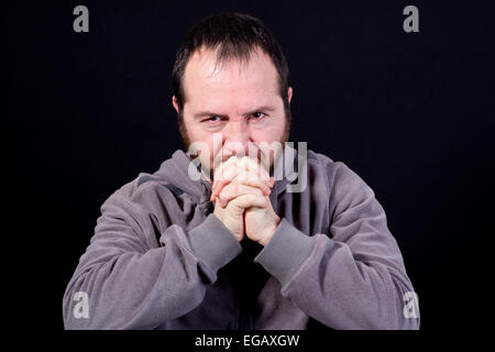 portrait of thoughtful sad young man isolated on black background Stock Photo
