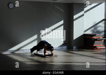 Man doing plank exercises alone at the gym Stock Photo
