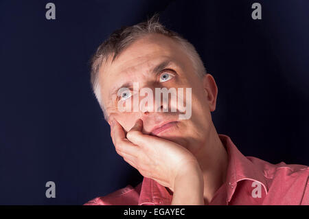 Studio portrait of a man in melancholy , looking up and holding his head Stock Photo