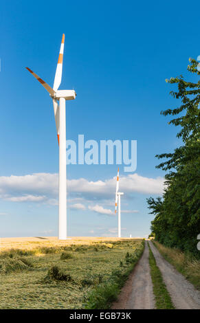 Wind turbines by a dirt road in the Eifel, Germany.