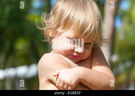 Outdoor closeup portrait of cute shy Caucasian blond baby girl Stock Photo