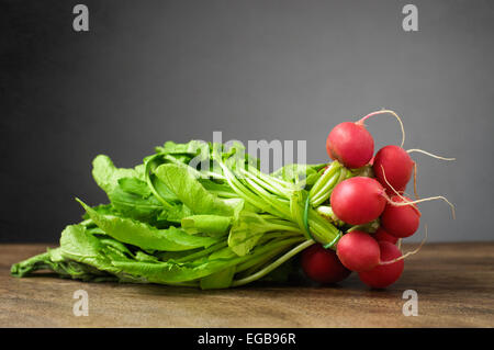 A bunch of fresh radishes on wooden table Stock Photo
