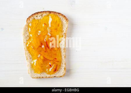 Toast with orange marmalade on a white table top view Stock Photo