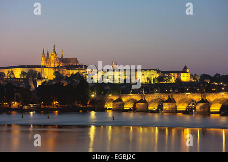 Prague at dusk showing Charles Bridge crossing the Vitava River with Prague Castle and St Vitus Cathedral in beyond. Stock Photo
