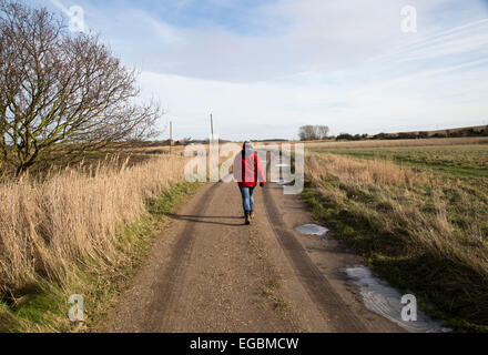 Model released woman walking along country track, Butley, Suffolk, England, UK Stock Photo