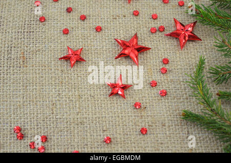 Red Christmas stars and a fir branch on a knitted table cover. Stock Photo