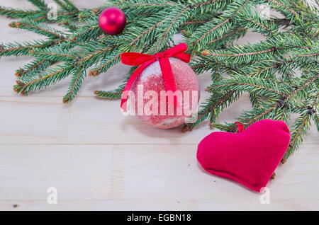 Red Christmas ornaments and a fir tree on a wooden table Stock Photo