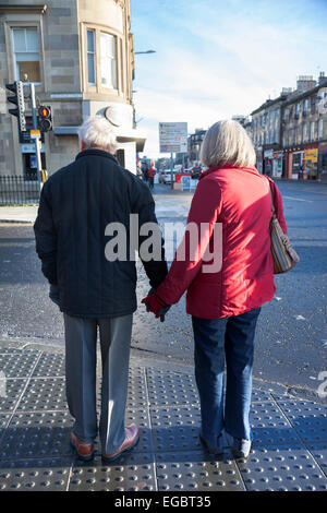 Elderly couple holding hands on the streets of Edinburgh Stock Photo