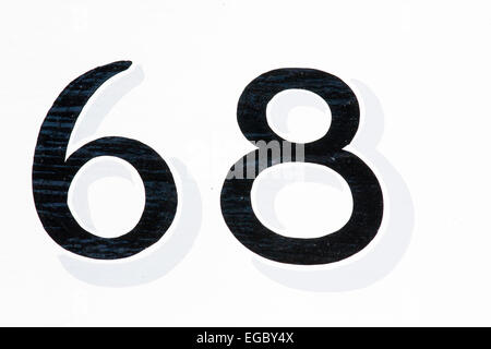England, Sandwich. Front door, street Number 68. White wooden door with number painted on in black with slight painted 3D effect shadow. Stock Photo