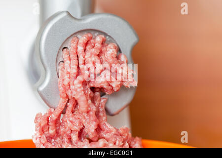 Closeup of minced meat coming out from grinder in shop Stock Photo