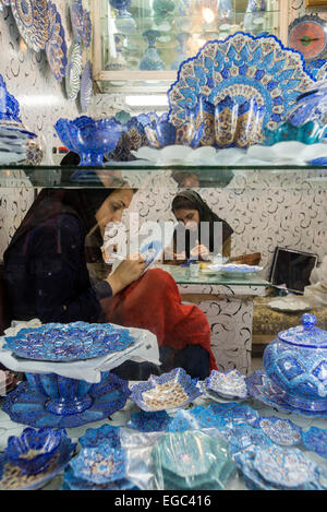 Artists paint cooper plates in Enamel Peykam shop on Emam Khomeini Square in Esfahan, Iran Stock Photo