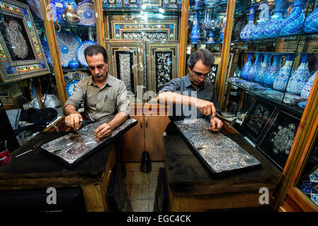 Artists emboss ghalamzani silver pieces, ghalamzani means art of embossing patterns on different metals such as copper, silver, gold, and brass, Esfahan, Iran Stock Photo