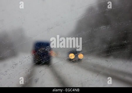 Luss, Scotland, UK. 22nd Feb, 2015. View through the windscreen as drivers significantly reduce speed on the A82 north of Glasgow as low visibilty, heavy snow and ice makes dangerous driving conditions. Credit:  PictureScotland/Alamy Live News Stock Photo