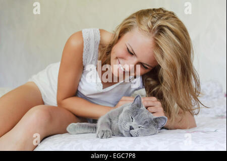 Young beautiful woman with british cat on the bed Stock Photo