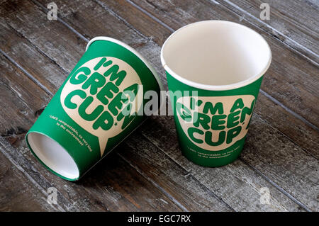 I'm a green cup printed on the front of a 100% compostable cardboard cup which is kind to the environment. Two on a wooden tray Stock Photo