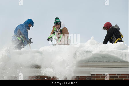 Lexington, MA, USA, 21 Feb, 2015.  Contractors clearing snow from the roof of a three story apartment building in Lexington, MA, before another snow and ice storm hits Eastern Massachusetts.   Credit:  Chuck Nacke/Alamy Live News Stock Photo