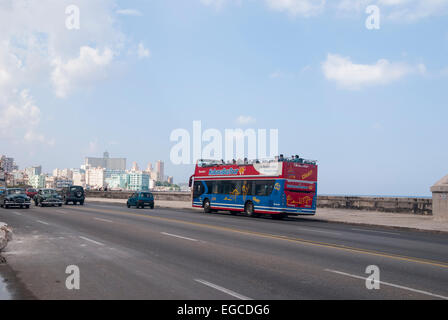 A double decker Cuban hop on hop off tourist bus traveling along the Malecon seafront boulevard in Havana Cuba Stock Photo