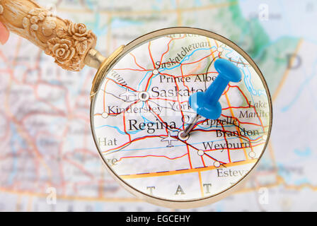 Blue tack on map of central Canada with magnifying glass looking in on Regina, Saskatchewan Stock Photo