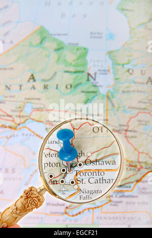 Blue tack on map  with magnifying glass looking in on Toronto, the capital of Ontario province, Canada