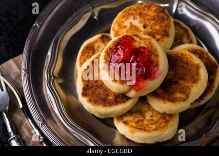 Cottage cheese pancakes with currant jam, closeup, top view Stock Photo