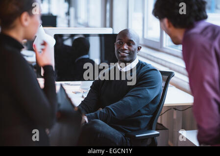 Image of young afro american man sitting at desk in office. Young executives at work. Stock Photo