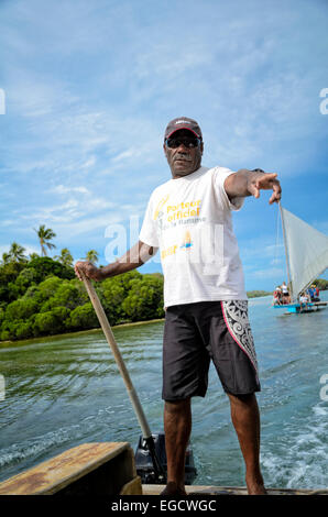 Captain of a pirogue, a small sail boat, in New Caledonia, South Pacific. Man new caledonia; steering; hand on tiller; old style sailing boat; boatman Stock Photo