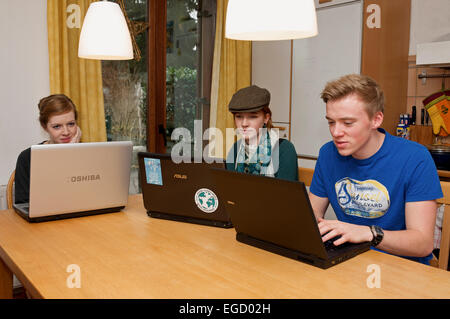 Teenagers at home using laptop computers Stock Photo
