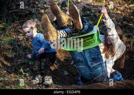 brothers and sisters playing on swing, child, black, garden, group, friends, two, fun, park, years, race, horizontal, sister, su Stock Photo