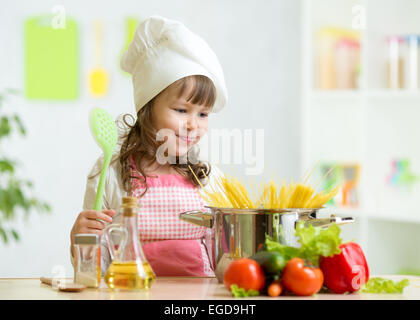 Cook kid makes healthy vegetables meal in the kitchen Stock Photo