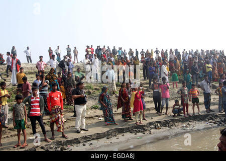 Paturia, Bangladesh. 23rd Feb, 2015. A large crowd gathers near Manikganj, western Bangladesh 23 February 2015 as the ferry that capsized in the Padma River 22 Feb is brought ashore. So far 69 bodies have been recovered out of the 150 passengers who were on board at the time of the collision with a cargo vessel. Stock Photo