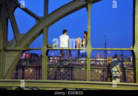 People sitting on the Hacker bridge in the evening, Munich, Bavaria, Germany Stock Photo