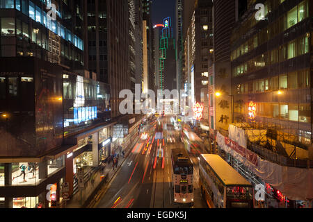 Des Voeux Road in Central Hong Kong with night time traffic shot at long exposure. Stock Photo