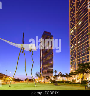 Modern sculpture in front of twin towers Hotel Arts and Mapfre Tower, illuminated, Olympic village, Barceloneta, Barcelona, Catalonia, Spain Stock Photo