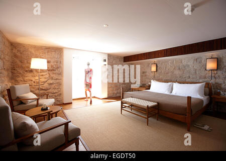 Woman inside a Deluxe Cottage bedroom, Aman Sveti Stefan, Sveti Stefan, Budva, Montenegro Stock Photo