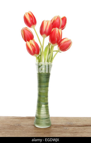 Bunch of tulips in a vase on a wooden board against a white background Stock Photo