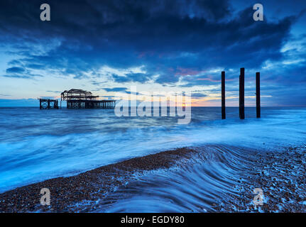 The decaying remains of Brighton's West Pier at sunset with the tide coming in. Stock Photo