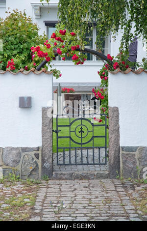 AHUS, SOUTH SWEDEN - JUNE 28, 2014: Pretty home entrance with white washed wall and roses on June 28, 2014 in Ahus, South Sweden Stock Photo