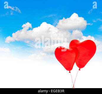 Heart shaped red air balloons in blue sky. Valentines Day background Stock Photo
