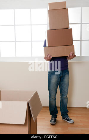 Man Carrying Stacked Boxes on moving day Stock Photo