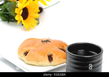 Red bean bread with green tea with flower background Stock Photo