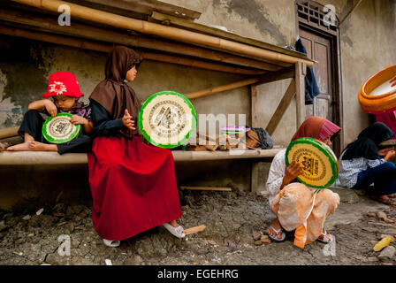 A group of rural children playing rebana, as they are training themselves for an Islamic music performance in Buni, Bekasi , West Java, Indonesia. Stock Photo