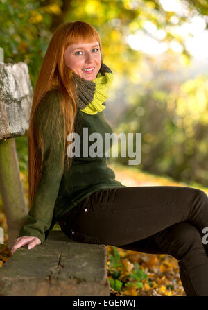 Beautiful long red haired woman in the autumn park Stock Photo