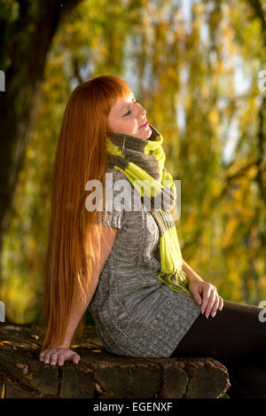 Beautiful-haired woman  enjoying the autumn sunshine Stock Photo
