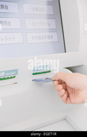 Japanese man using ATM in a convenience store Stock Photo