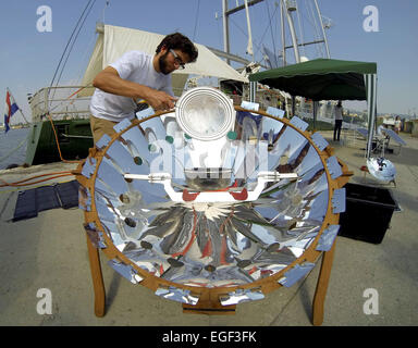 A crew member cooks some food onboard Greenpeace's Rainbow Warrior using a solar powered device. The ship, which arrived in Bulgaria on Tuesday night (19Aug14), is currently embarking on a European tour covering 10 countries during which Greenpeace will p Stock Photo